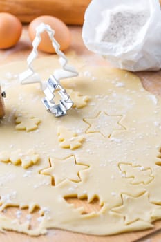 Christmas baking - dough with cookie cutter and baking ingredients. Homemade bakery, xmas sweet, winter holidays concept.