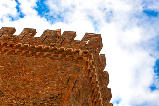 the old castle on the background of blue sky with clouds