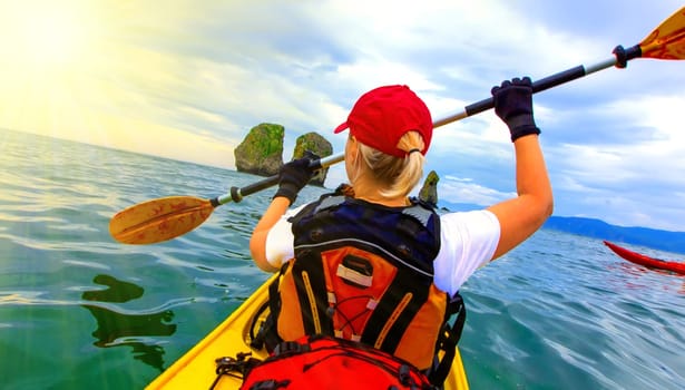 The Woman paddles kayak on Pacific ocean