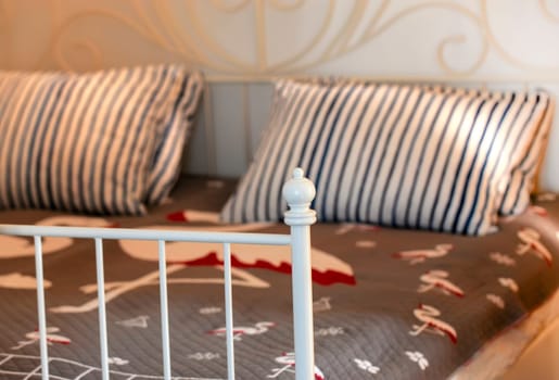 The stylish bedroom interior design with patterned pillows on bed. Selective focus