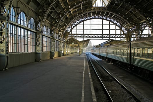 Railroad station platform in Saint Petersburg, Russia, with hanging clocks and "Have a nice trip"" signboard."