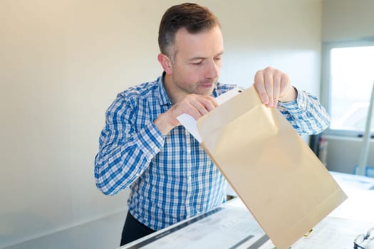 positive businessman opening an envelop