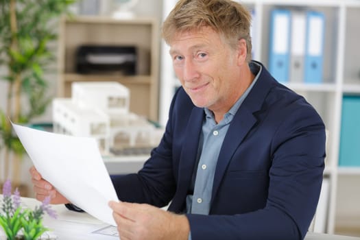 adult businessman in suit is laboring with concentration