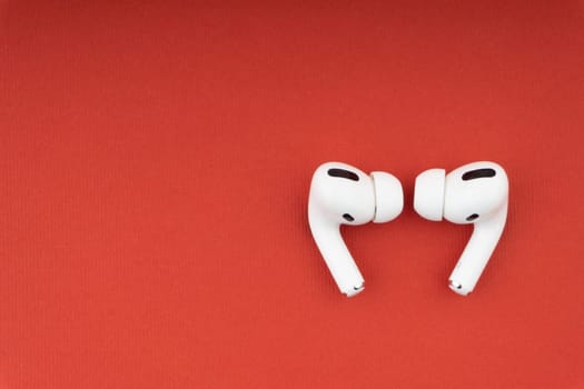 Kuala Lumpur, Malaysia - December 1,2020 : AirPods Pro on red background