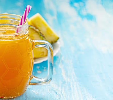 The Pineapple juice or smoothies in a mug with a pen on a blue wooden table