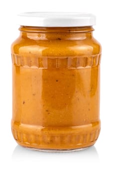 The glass jar with squash caviar on white background