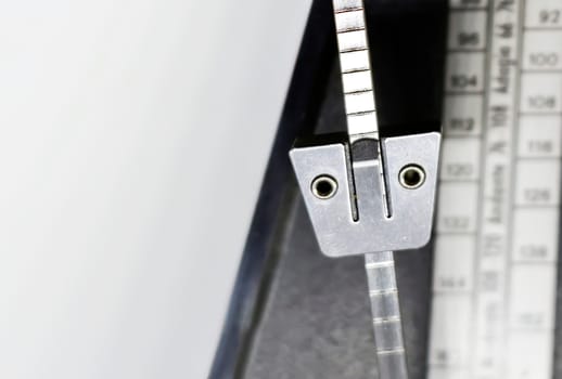 Detail of the pendulum of a classic metronome. Rhythm measurement tool. Mechanical movement without electricity