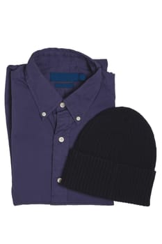 Closeup of a folded stylish dark blue shirt and a black cap or hood isolated on a white background. Mens fashionable outfit.