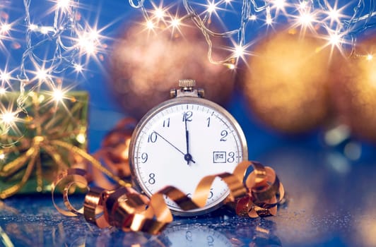 Old golden clock close to midnight and sparkling Christmas decoration - New Year concept