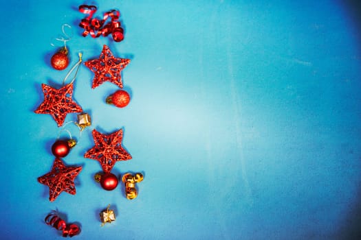 Vintage Christmas background with red Christmas decorations on blue.