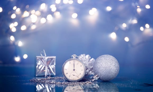 Old silver clock close to midnight and sparkling Christmas decoration - New Year concept