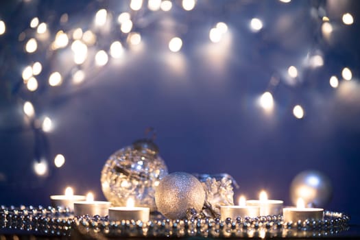 Silver Christmas balls over sparkling holiday background. Magic holiday lights. Merry Christmas and a Happy New Year