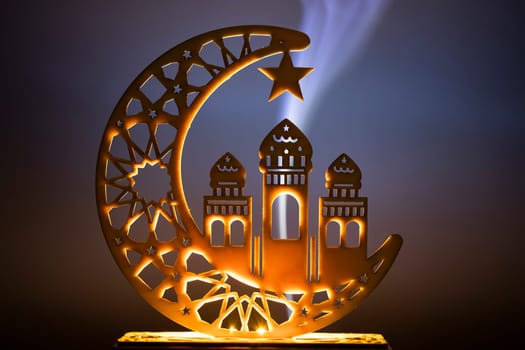 Ornamental Arabic decoraion with burning candle glowing at night and glittering golden bokeh lights. Festive greeting card for Muslim holy month Ramadan Kareem.