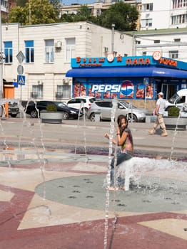 ROSTOV-ON-DON, RUSSIA-AUGUST 28 - A girl covers her ass fountain and having fun at the same time August 28, 2013 in Rostov-on-Don