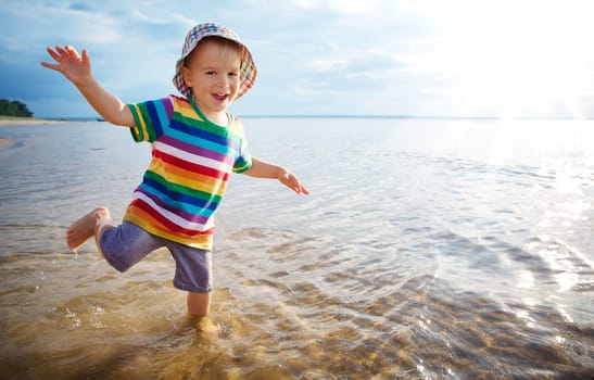 happy boy playing at sea. Child os on vacation in summer at the beach