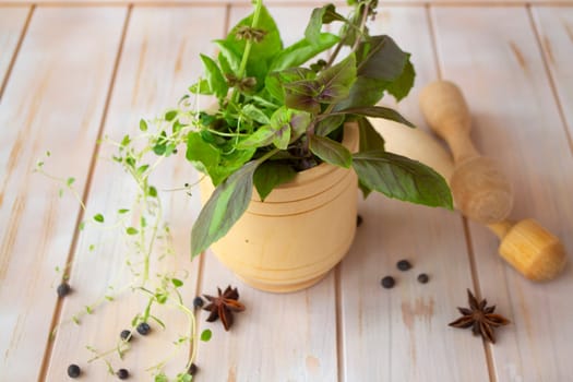 A mix of Italian herbs in a vase with cinnamon and seasonings on rustic table