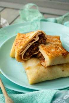 Sweet crepes filled with apple jam for breakfast, vertical image