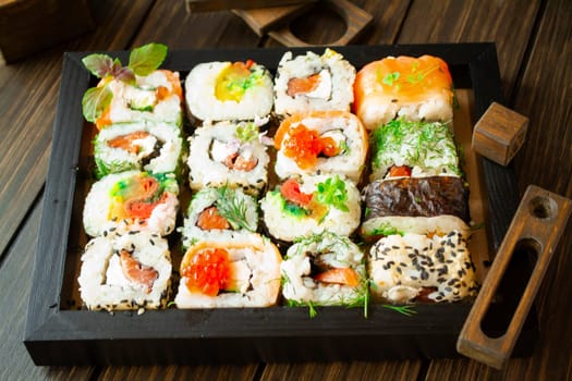 Food art. Great set of sushi served in colorful ornament on brown square. Luxury restaurant
