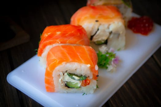 Philadelphia roll sushi with salmon, prawn, avocado, cream cheese. Close up