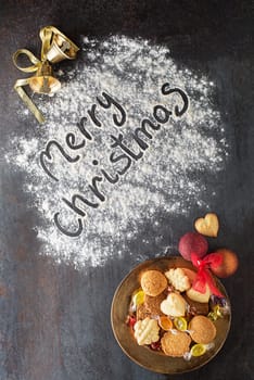Merry Christmas text made with flour with decorations objects and cookies. Christmas, winter, new year concept background.