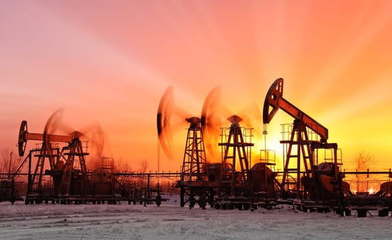 oil pumps at sunset sky background