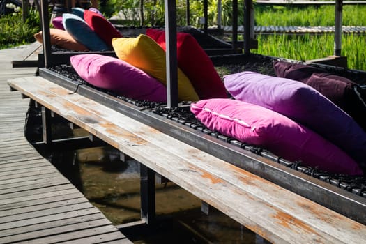 Colorful pillows on net seat among nature, stock photo