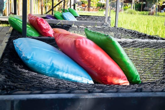 Colorful pillows on net seat among nature, stock photo
