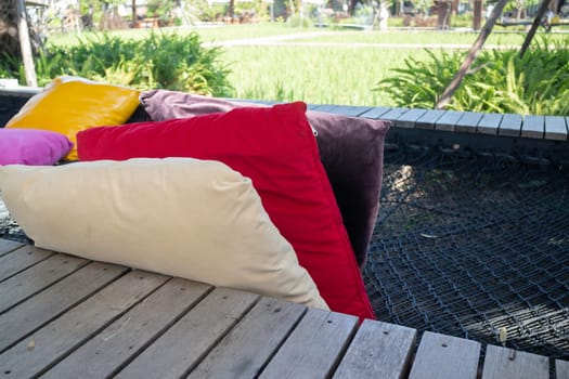 Colorful pillows on net seat among nature, stock photo