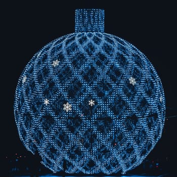Huge glowing decoration Christmas Tree Ball on the street of the night city. Festive New Year background in shades of color of the year 2020 - Classic Blue.