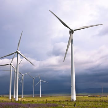 Wind turbines generating electricity in a stormy weather.