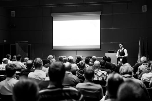 Speaker Giving a Talk at Business Meeting. Audience in the conference hall. Business and Entrepreneurship concept. Black and white.