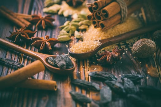 Fragrant spices for Christmas baking on wooden background.