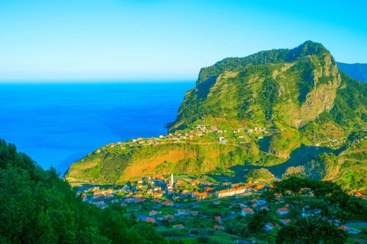 Landscape with Maderia village, mountains and ocean in at sunset. Madeira island, Portugal