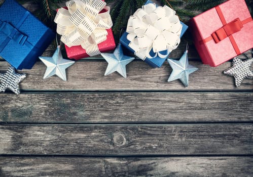 Christmas stars on wooden background with fir tree branches. Winter background with presents