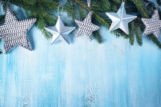 Christmas stars on wooden background with fir tree branches. Winter background
