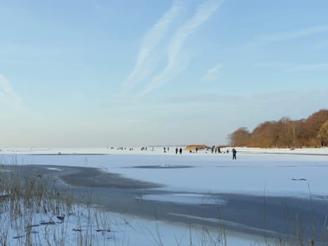 winter  ice fishing  crowd of people on the ice of a frozen and snow-covered lake catching fish