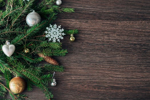 Decoration of Christmas Tree Green Branches on a Brown Background with Copy Space