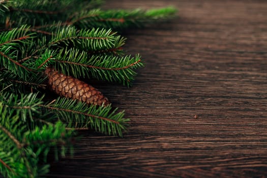 Decoration of Christmas Tree Green Branches on a Brown Background with CopySpace
