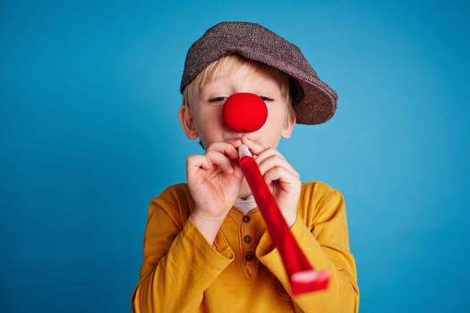 Little boy blowing a party horn blower