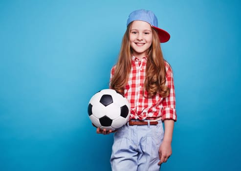 Smiling girl keeping white black ball
