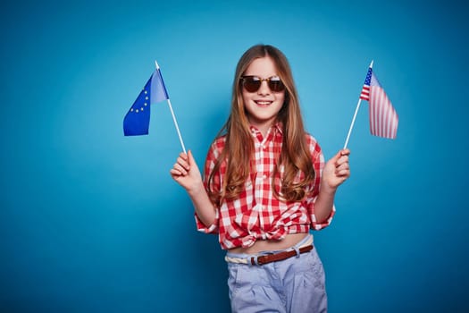 Nice girl keeping European Union and American flags on a stick