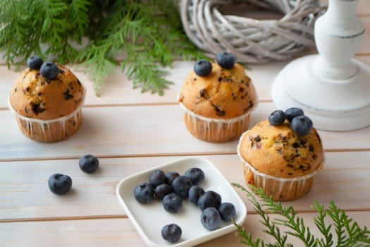 mascarpone and fresh blueberry muffins on white shabby wooden table