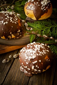 Home made buns, traditional easter bread, catkins on brown wooden background with osier branch