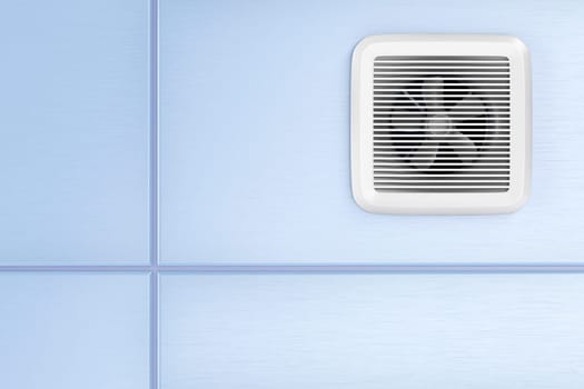 Exhaust fan mounted on the blue tiles in the bathroom