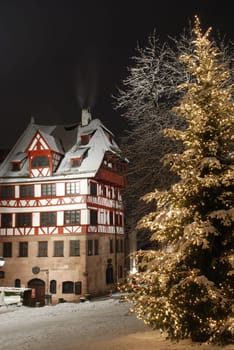 The historic Nuremberg Albrecht Dürer House on the Tiergärtnertorplatz at night during Christmas time and snowy