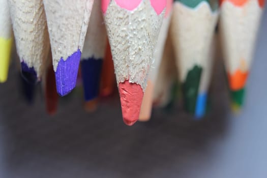 Close-up view of bright colored multicolor pencils on black background