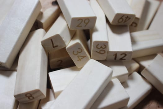 Pile of wooden blocks with engraved letters dispersed on floor. Children toy for building creative works.