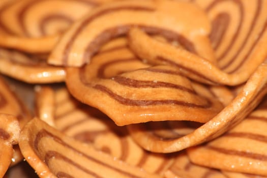 Closeup view with selective focus of a large number of round cookies with coconut filling lines.