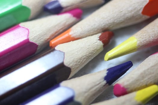 Close-up view of bright colored multicolor pencils on black background