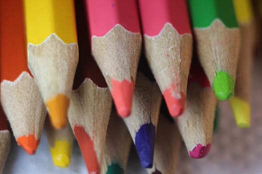 Close-up view of bright colored multicolor pencils on black background